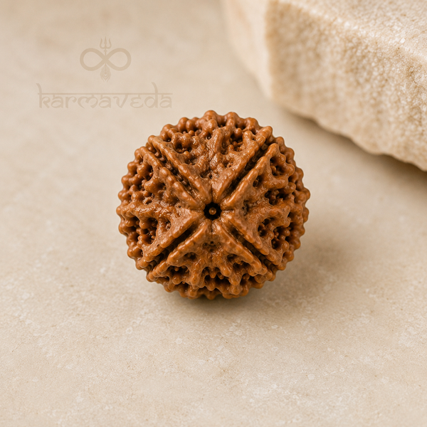 Brown textured object on a beige surface with 'karmaveda' branding.