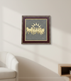 Framed artwork with a gold design on a gray background, displayed on a wall above a white sofa.