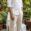 Person wearing a white shirt and beige pants in a garden setting