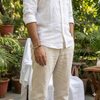 Person wearing a white shirt and beige pants in a garden setting