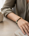 Person wearing a beaded bracelet on a desk