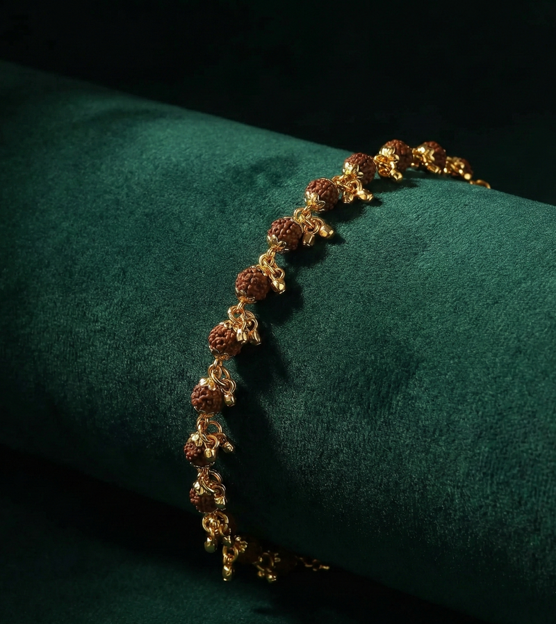 Gold bracelet with brown beads on a green cushion