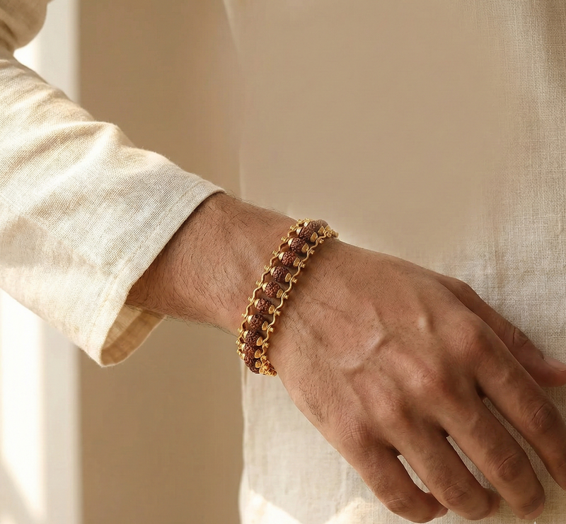 Gold bracelet on a wrist with a neutral background