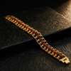 Gold bracelet with brown beads on a dark stone surface