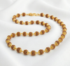 Necklace with brown and gold beads on a white background