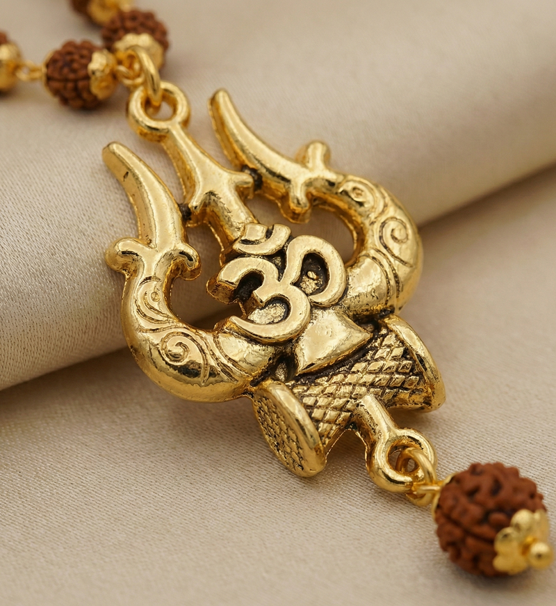 Gold necklace with intricate design and brown beads on a beige fabric background