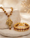 Gold necklace and bracelet set on a stone surface with a neutral background