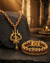 Gold necklace and bracelet set on a dark stone surface with a warm, blurred background.