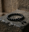 Black beaded bracelet on a stone surface