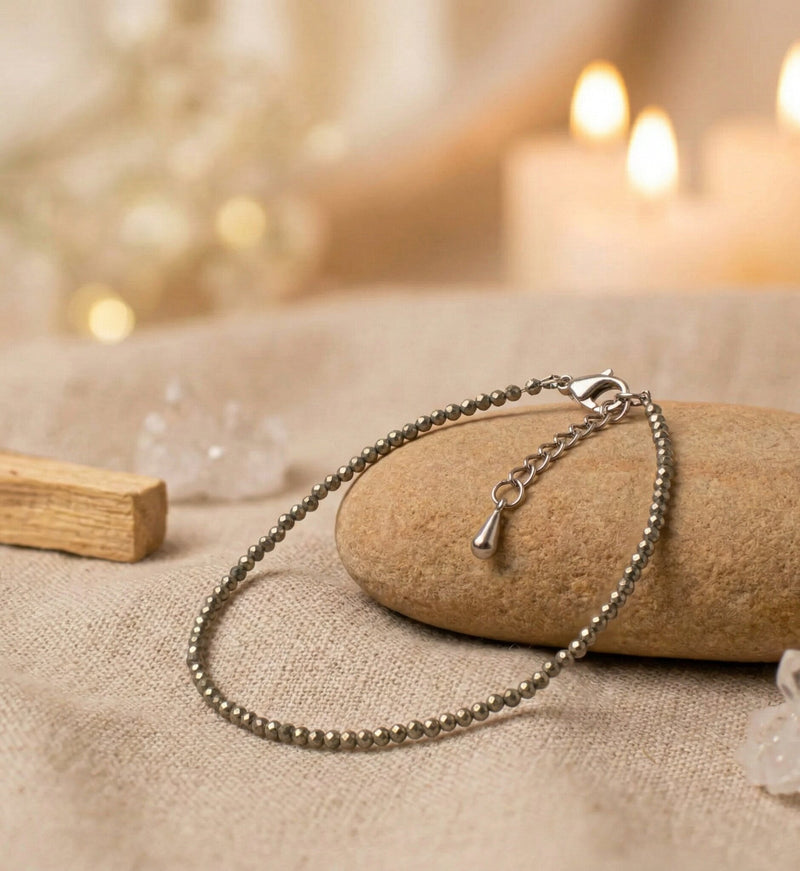Silver bracelet on a stone with blurred candles and crystals in the background