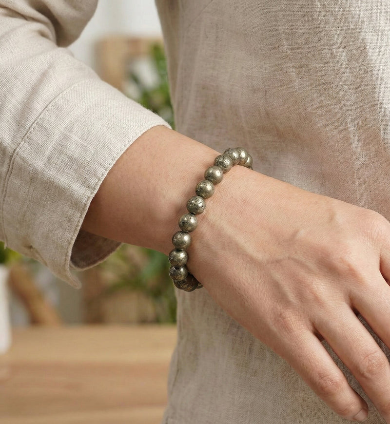 Person wearing a beaded bracelet on a blurred indoor background