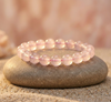 Pink beaded bracelet on a stone with a blurred natural background