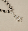 Black beaded rosary with silver cross on a beige background