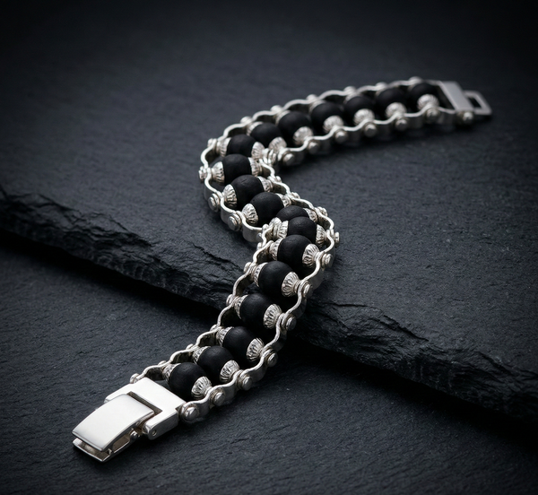 Black and silver chain bracelet on a dark stone surface