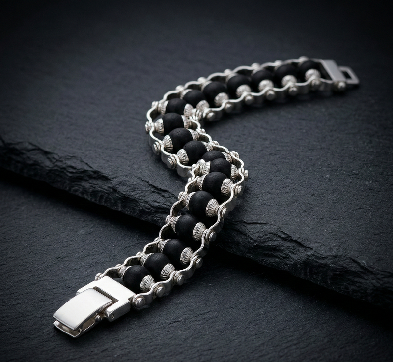 Black and silver chain bracelet on a dark stone surface