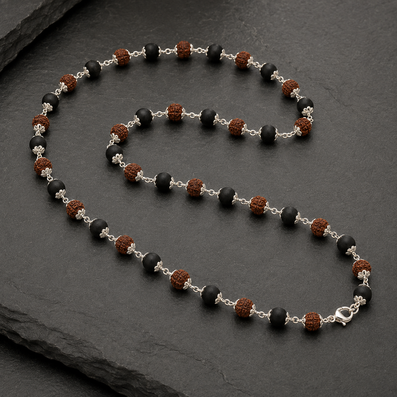 Necklace with black, brown, and silver beads on a dark surface