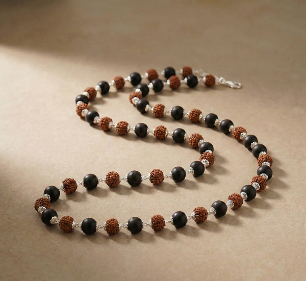Necklace with black, brown, and silver beads on a beige background