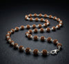Necklace with brown and silver beads on a dark background