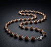 Necklace with brown and silver beads on a dark background