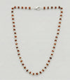 Necklace with alternating brown and white beads on a light gray background