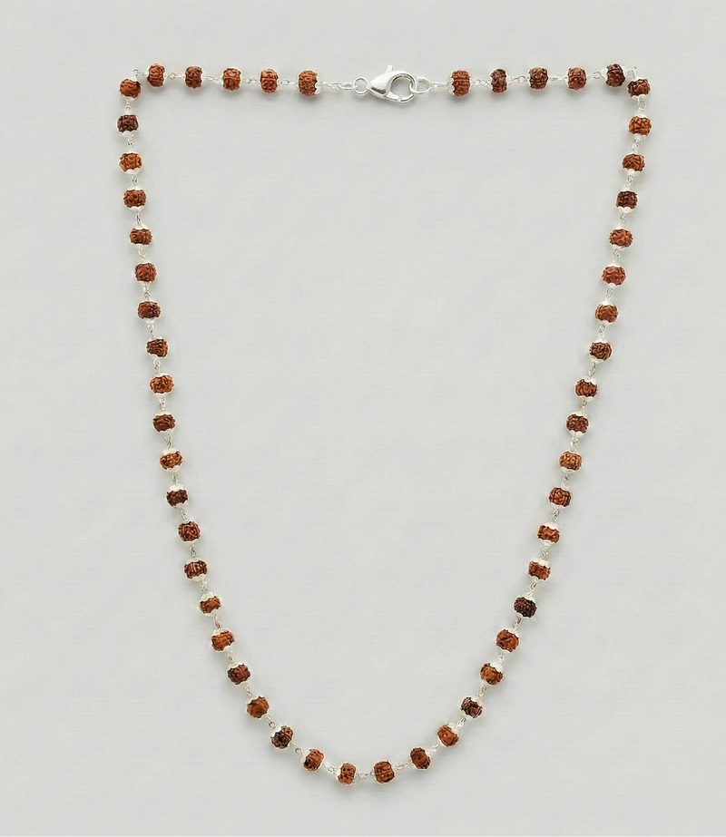 Necklace with alternating brown and white beads on a light gray background