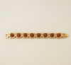 Gold bracelet with brown stones on a beige background
